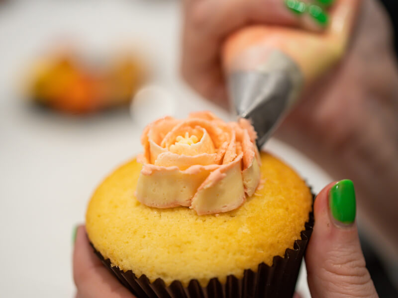 A cupcake being iced at a baking class.