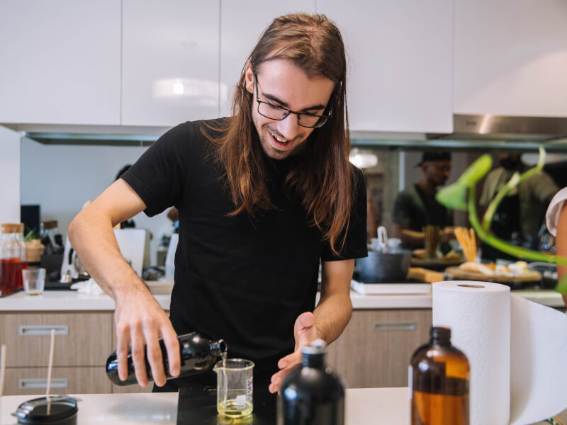 A man with long hair making a candle at a candle class