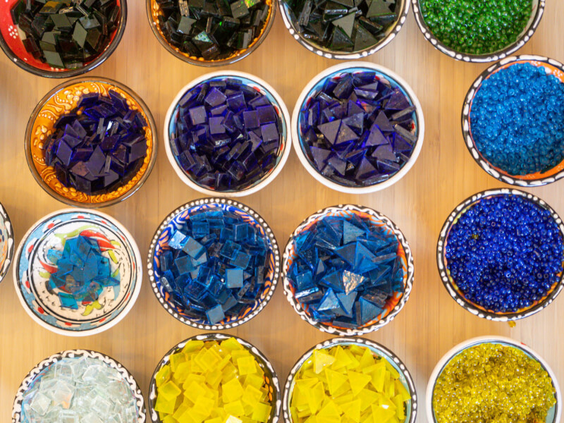 Several bowls filled with glass pieces to be used in a glass mosaic workshop.