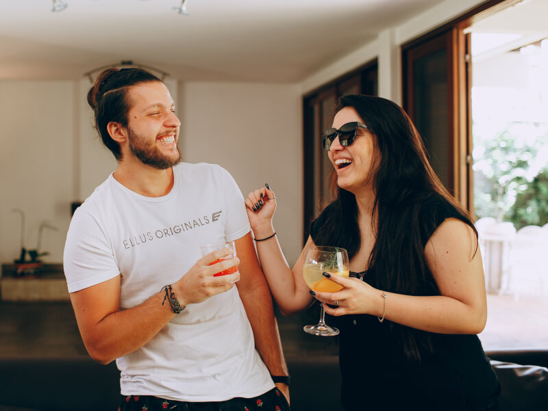 Two people laughing whilst enjoying delicous cocktails
