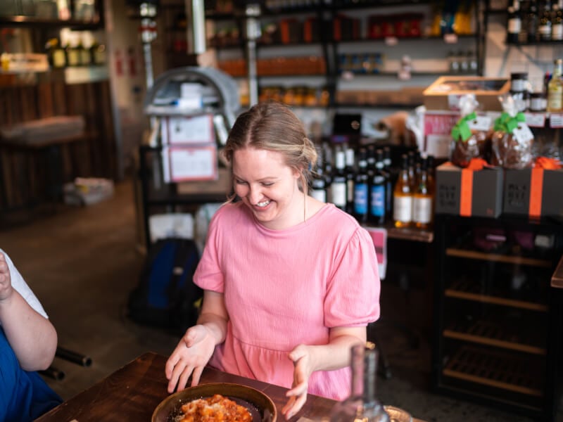 Woman smiling at bowl of homemade pasta