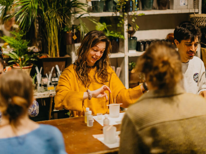 A group of people smiling while enjoying a candle making class together