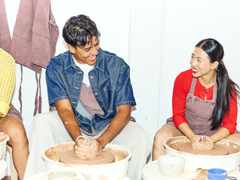 Two people wheel throwing 