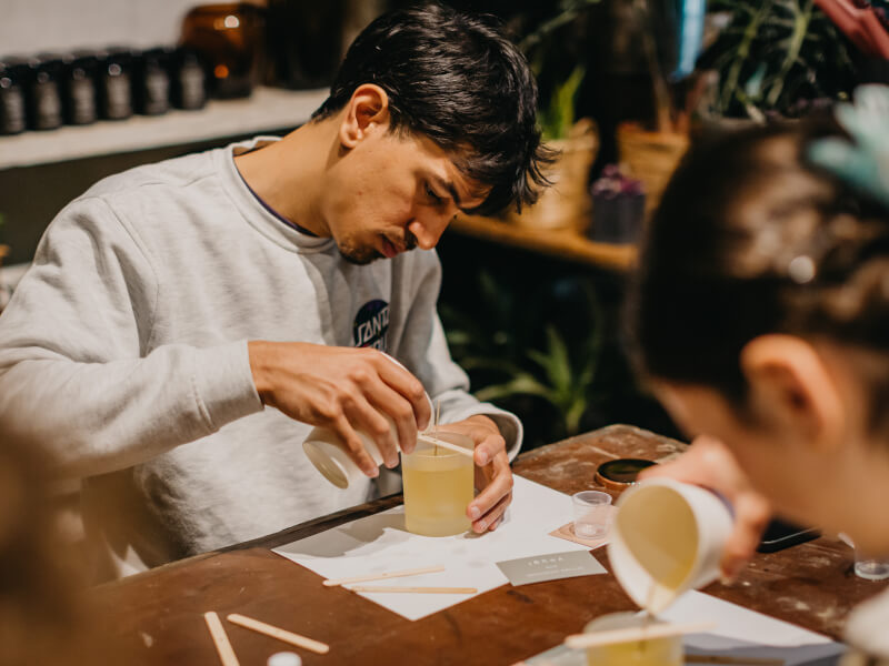 A man pouring a candle at a candle making class