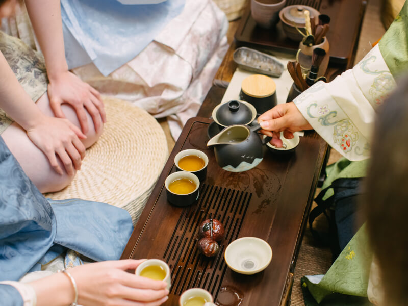 A close up of someone pouring from a jug at a tea tasting ceremony