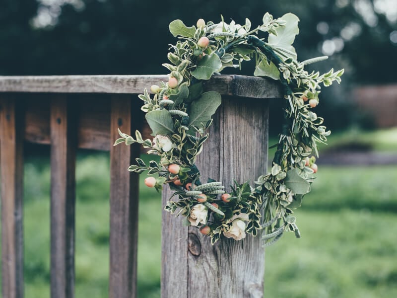 A flower crown resting on the side of a wooden bench