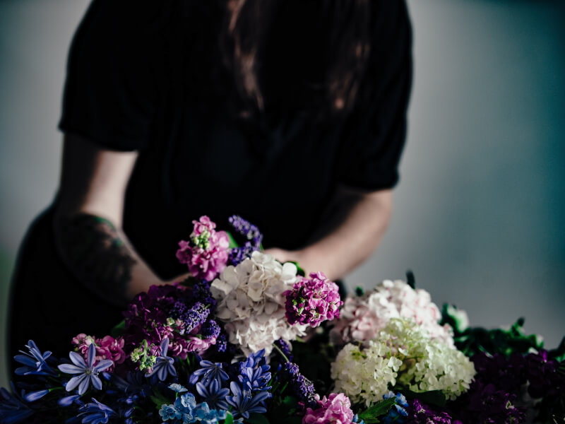 A person creating a floral arrangement