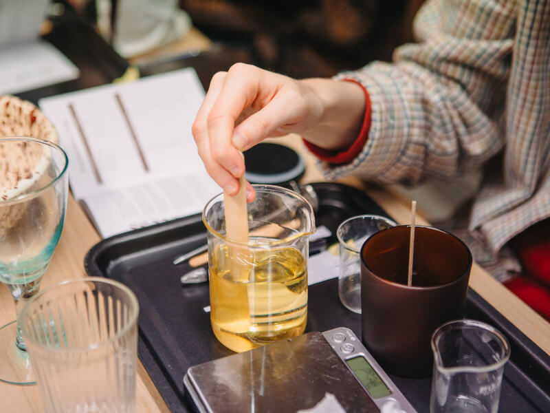 A close up of a person making an aromatherapy candle at Cedar Lifestyle