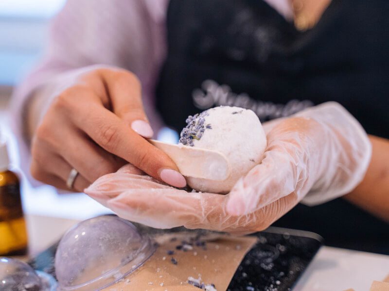 A close up of a persons hands holding a DIY lavender bath bomb