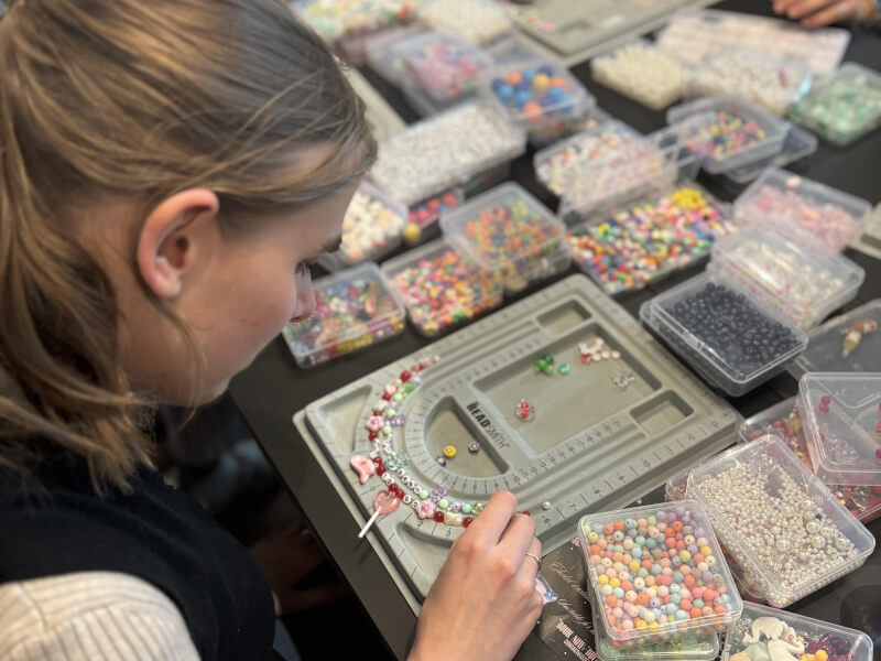 A woman organising beads in a jewellery making class