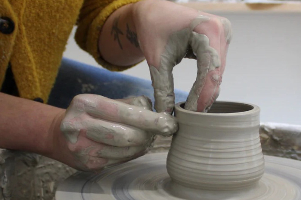 Close up of hands working clay on a pottery wheel