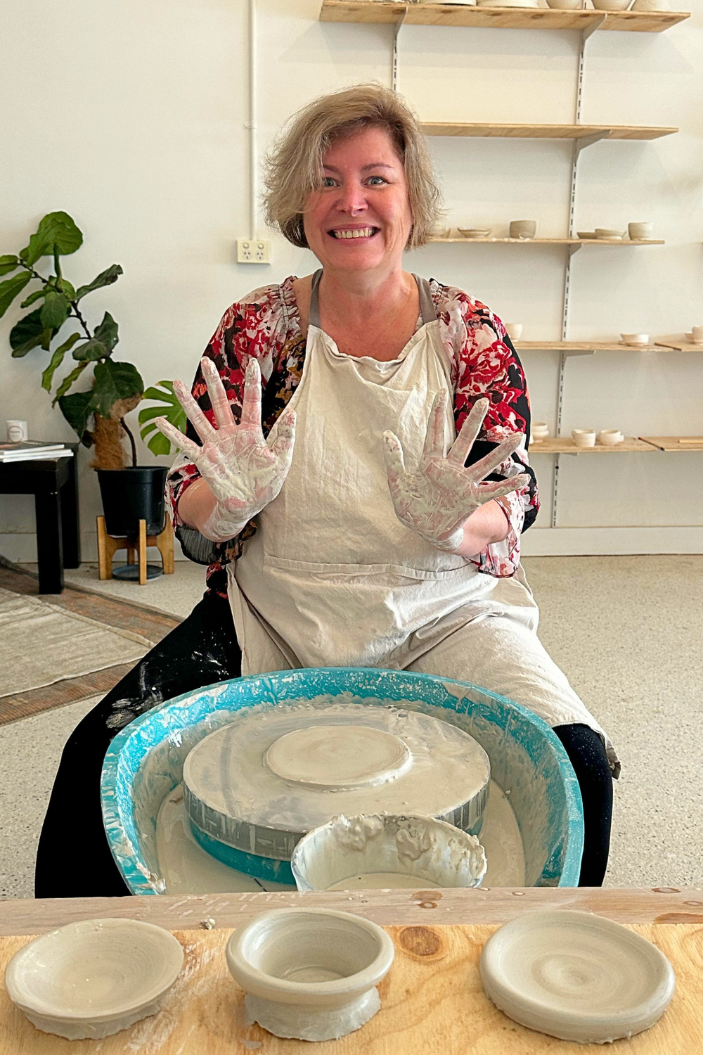 Woman wheel throwing at a pottery class.