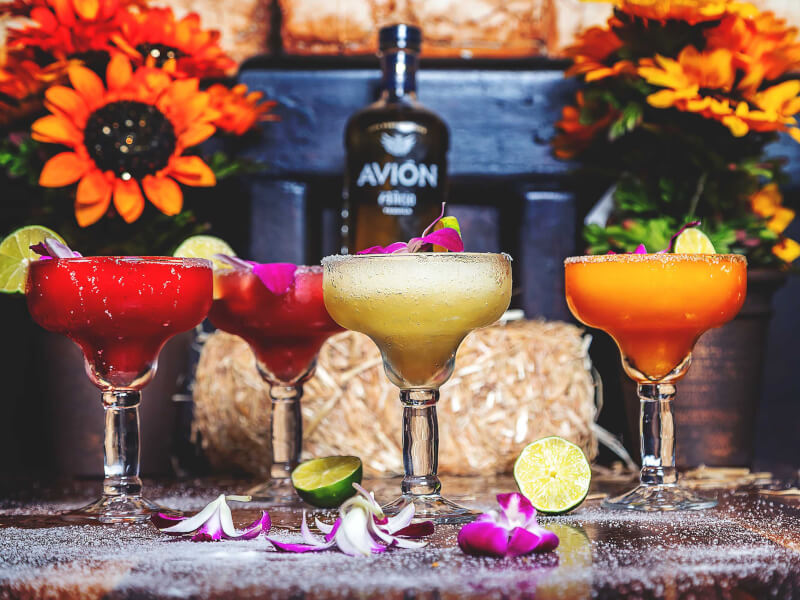 Several cocktails on a table decorated with flowers