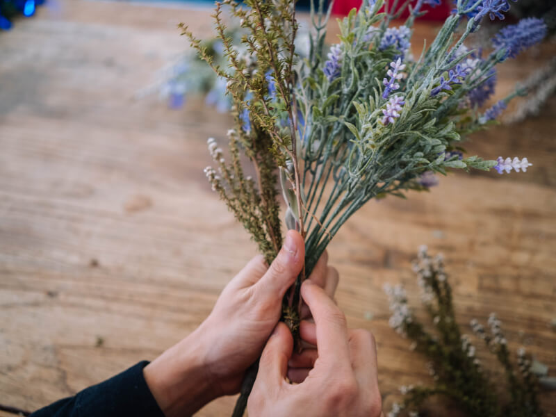 A person is holding a bunch of dried lavender and foliage 
