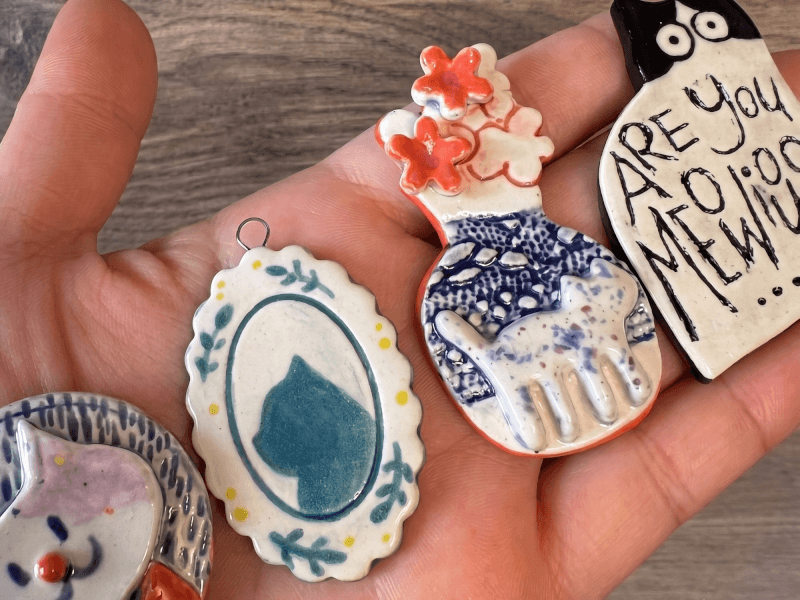 A handful of unique painted ceramic charms