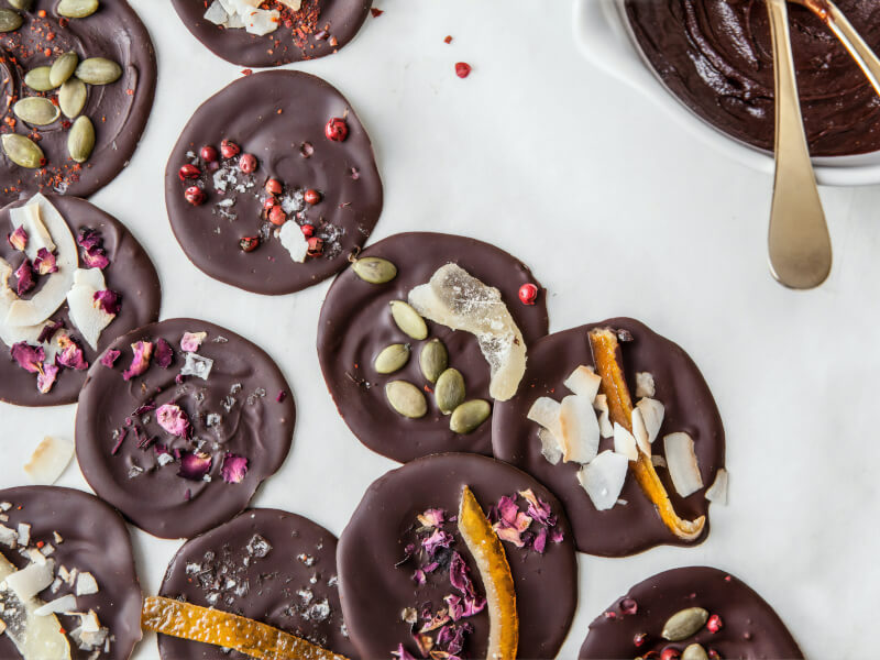 A selection of chocolate florentine style chocolates in milk chocolate, topped with nuts and fruits