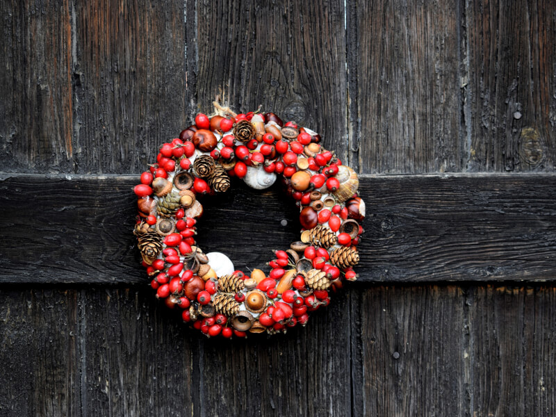 A handmade christmas wreath hanging on a wooden door