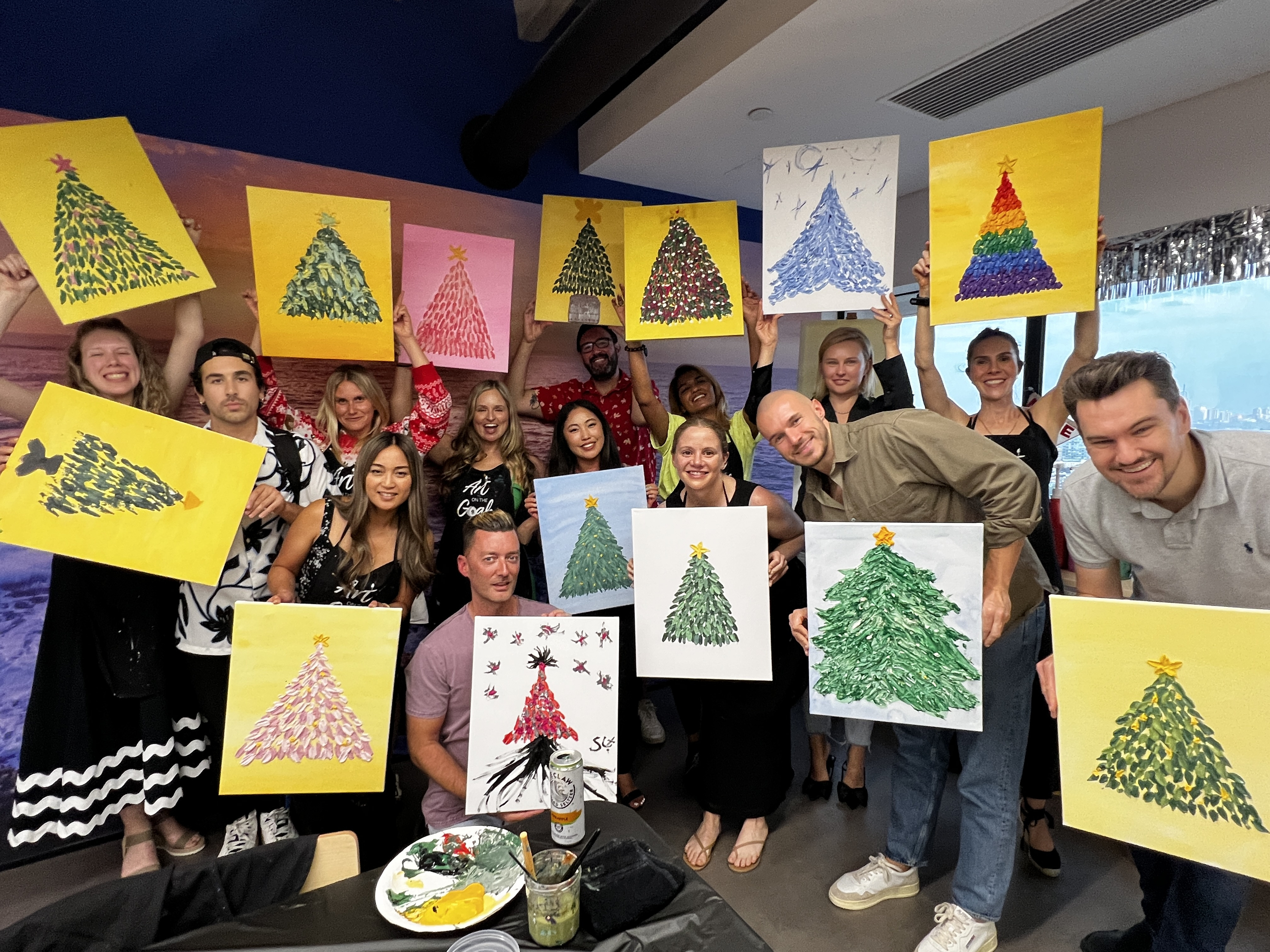 A group of people showing off festive paintings