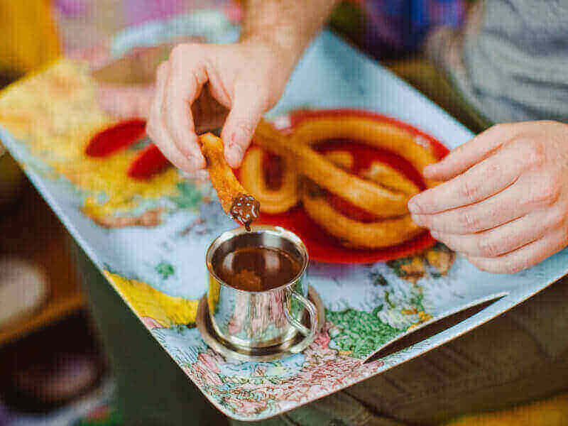 Churros dipped in chocolate in a food class