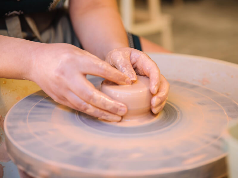 Close up of a person working clay on a potter's wheel
