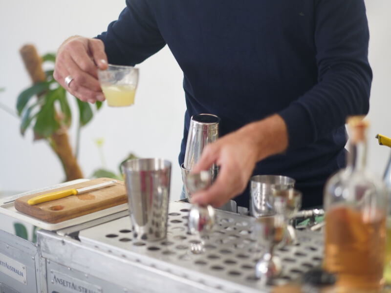A man pours drinks at a cocktail class