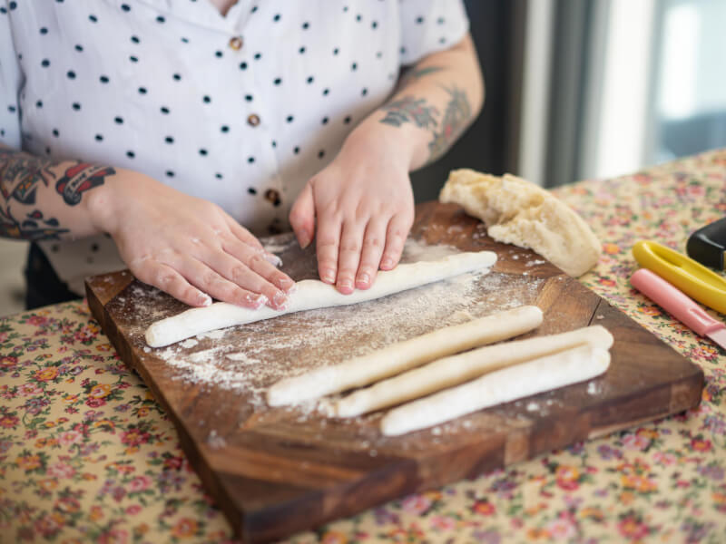 A close up of a person making gnocchi by hand 