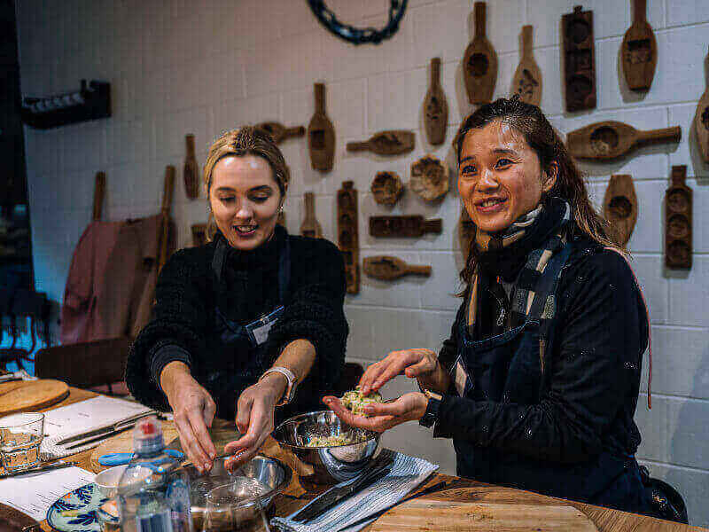 Two women making food in a cooking class