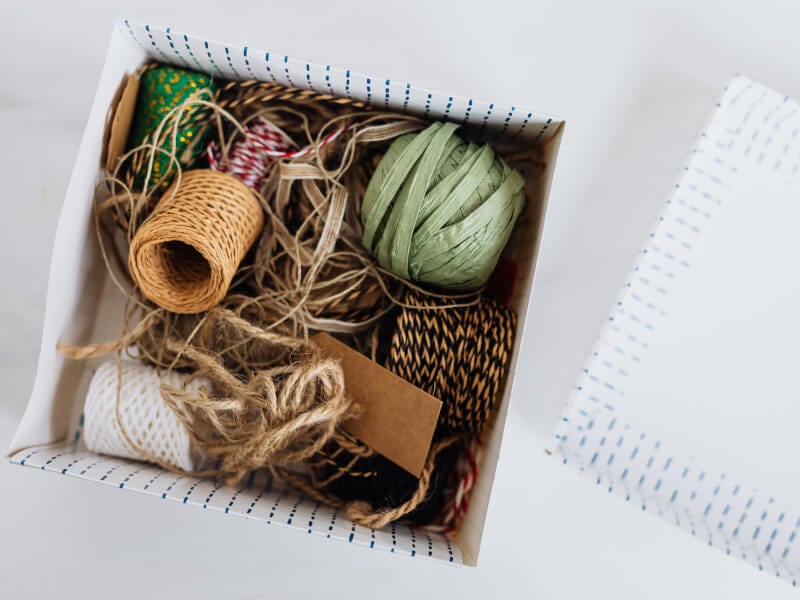 a white box full with a variety of coloured threads and strings of different sizes.