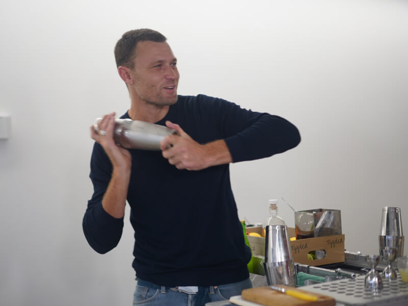Man shaking a cocktail shaker at a cocktail class