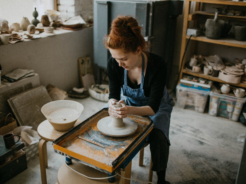 A woman at a wheel throwing pottery class in Portsmouth.