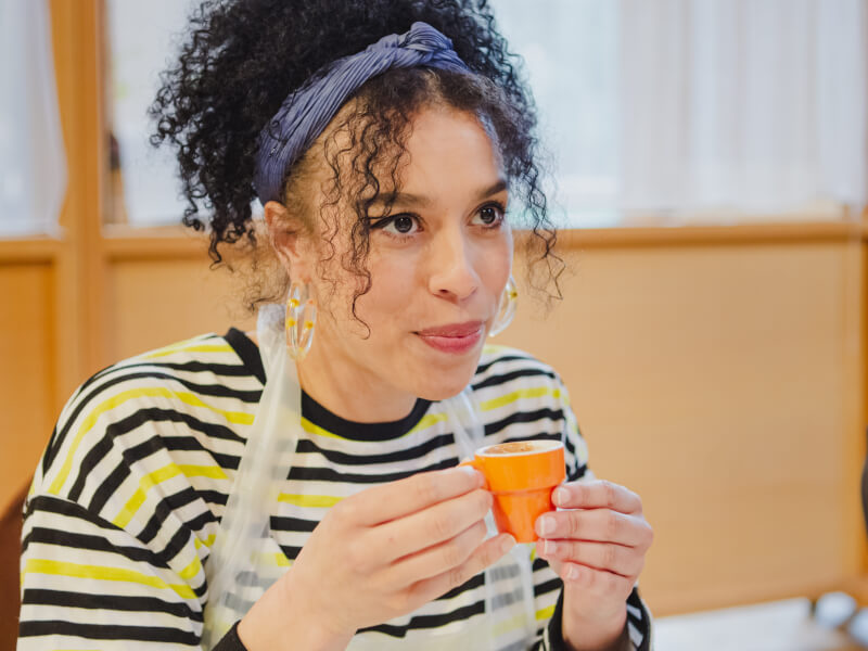 Woman holding espresso cup at a chocolate tasting.