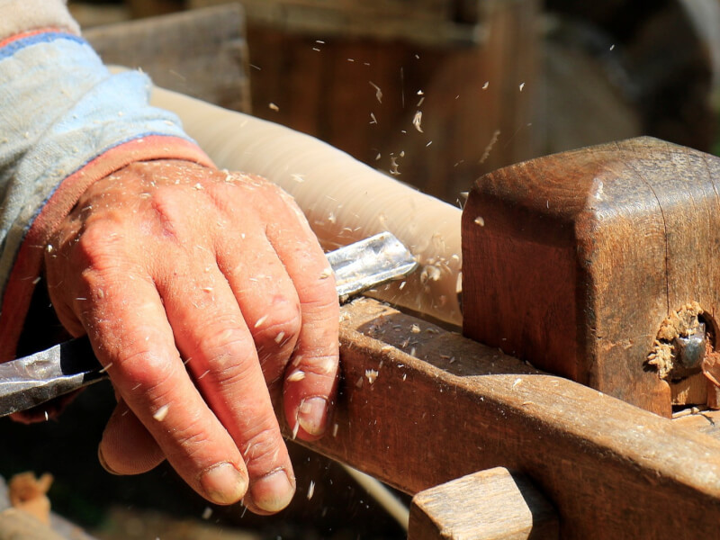 A person is using a hand tool for wood trimming.