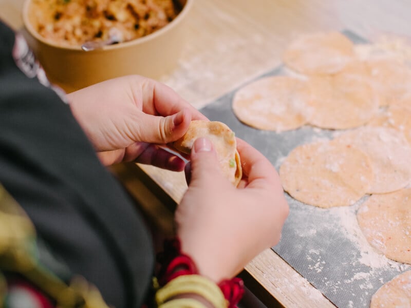Hands shaping dumplings in a cooking class