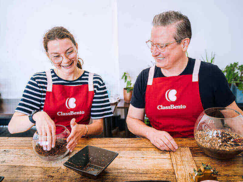 Smiling man and woman in a terrarium making workshop