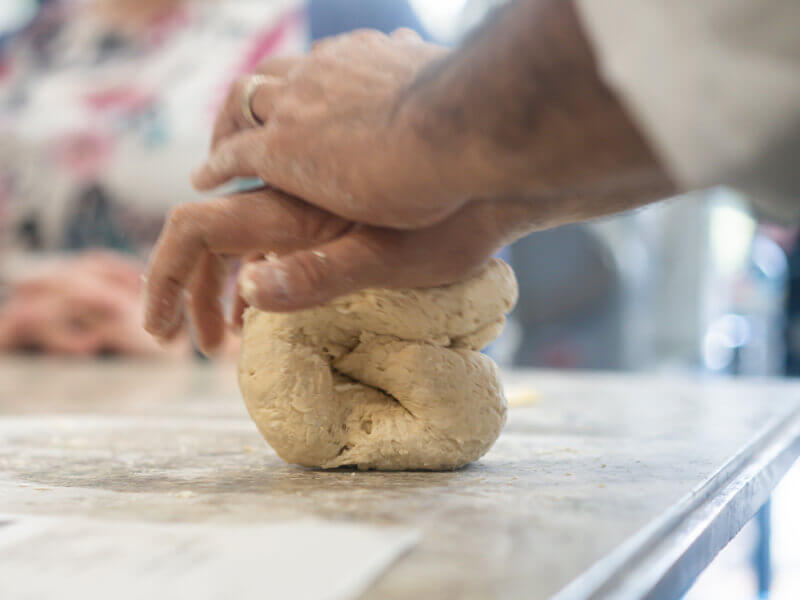 A person is kneading dough on a worktop