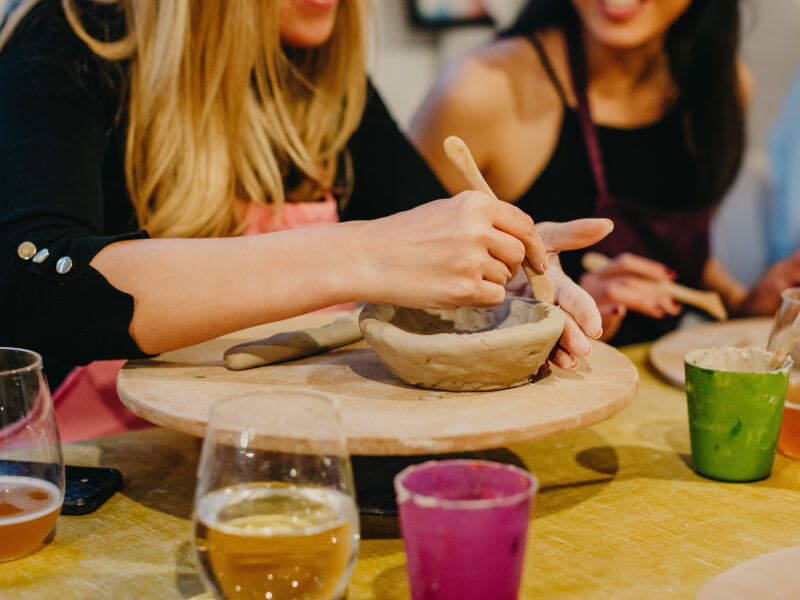 A close up of a person making a clay bowl using hand building techniques