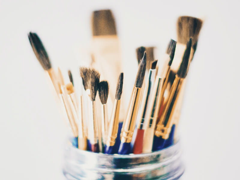 Several paintbrushes in a glass pot