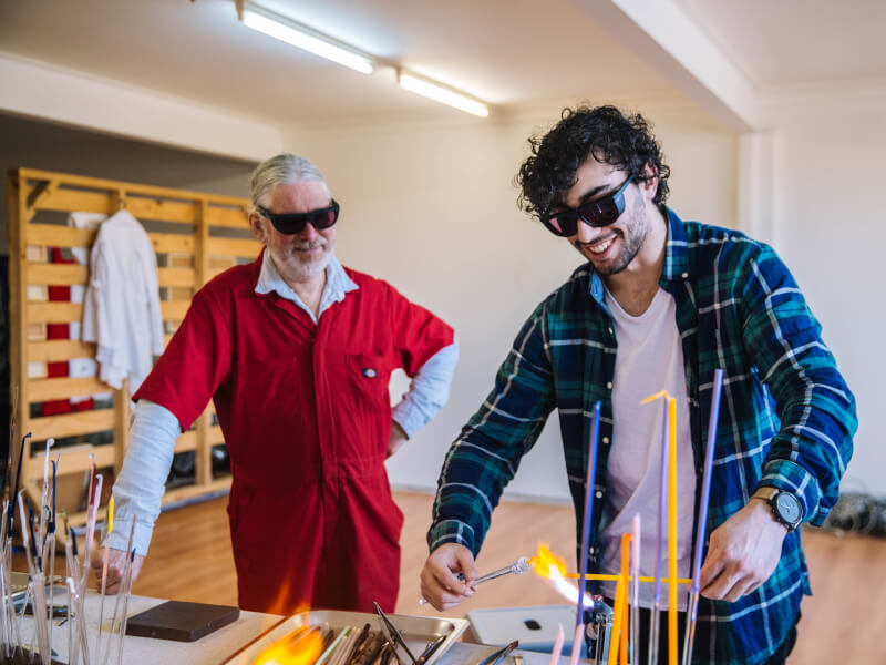 Two men heating glass to try glass art