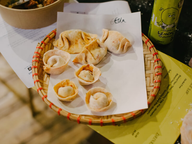 A basket of freshly cooked Asian dumplings sits on a worktop