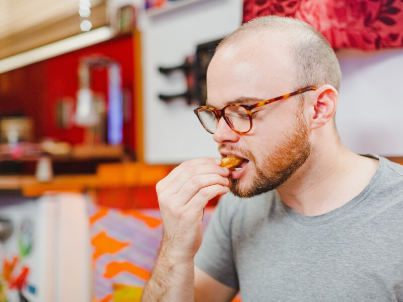 A man is eating a churro at a chocolate making experience