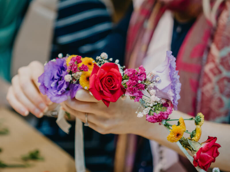 A close up of a person holding a DIY flower crown.