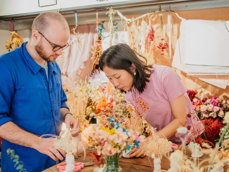 Man and woman arranging dried flowers in a floristry class