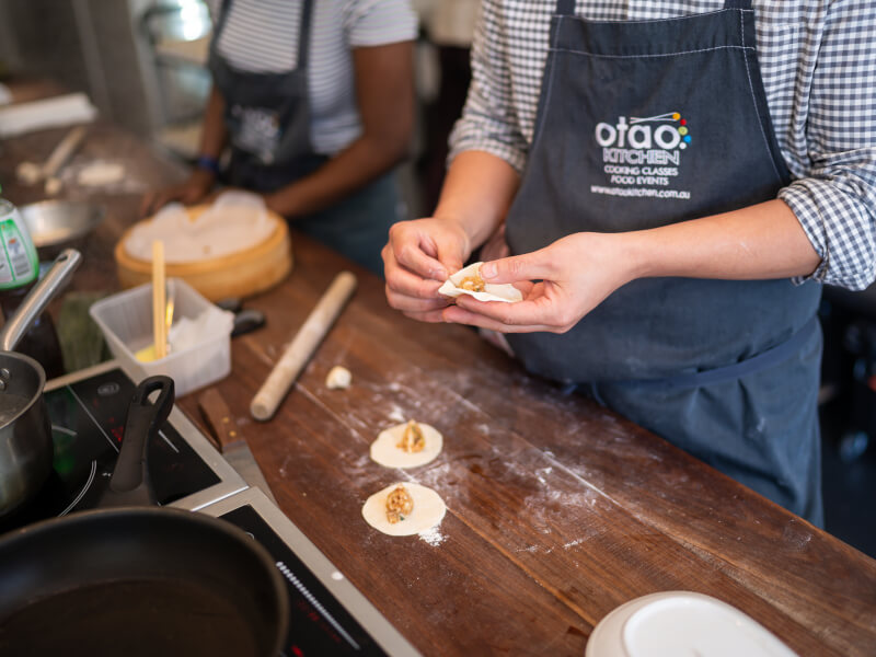 A close up of a person making won tons at a cooking class