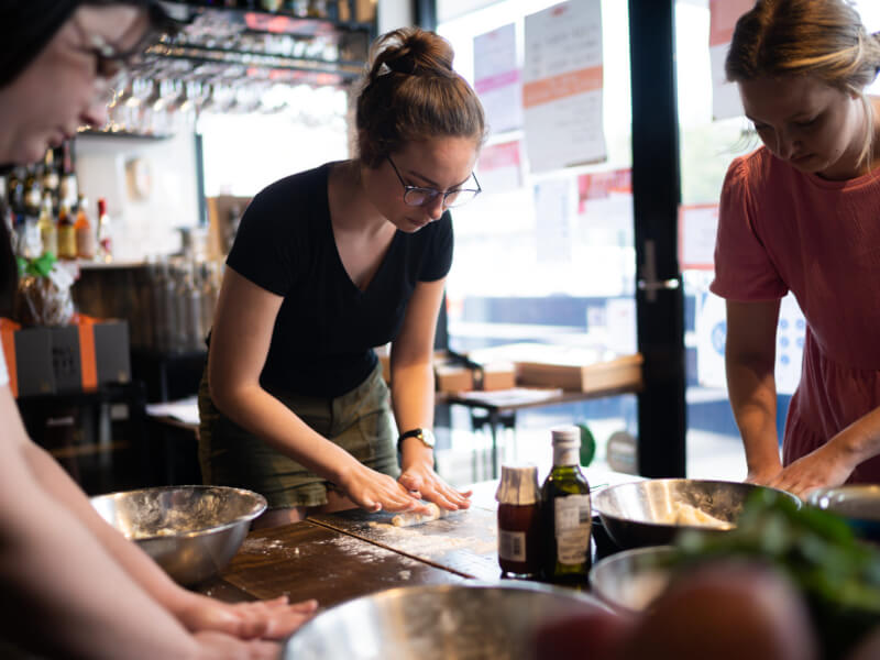 A group of people making gnocchi at a pasta making class