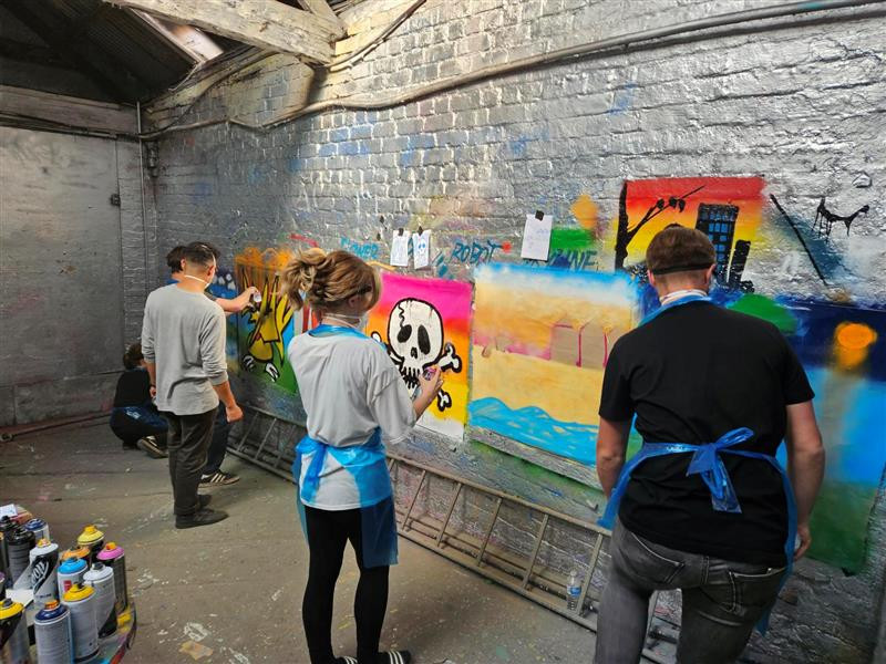 A group of people posing at their graffiti art class