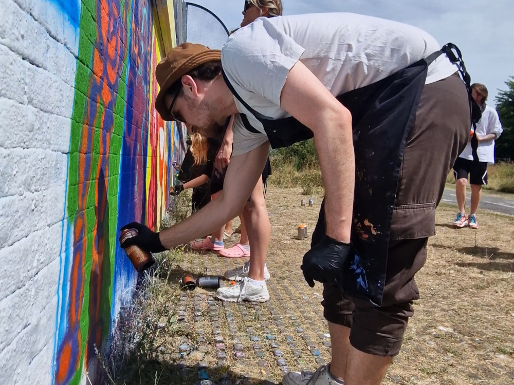 A person using a spraycan to make graffiti art