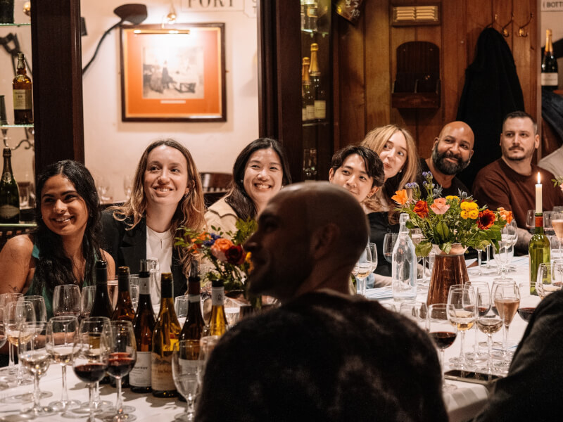 A group of people sitting round a table at a champagne tasting experience