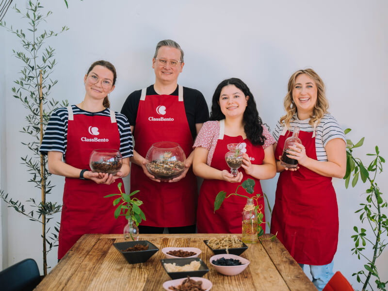 A group holding handmade terrariums and smiling