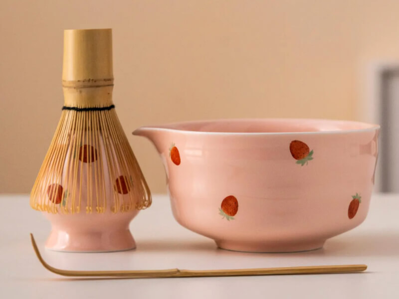 A pink matcha set hand painted with strawberry motifs