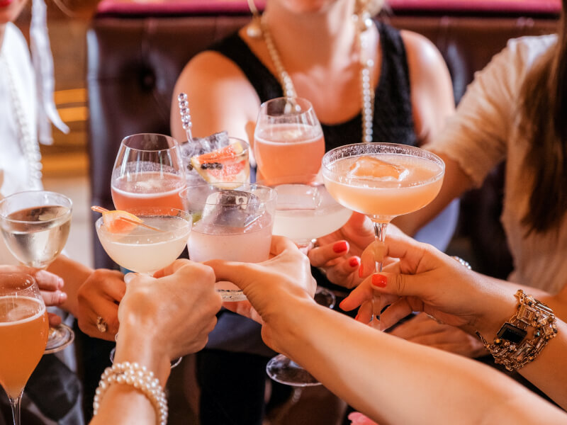 A group of girls clink classes at a cocktail class.